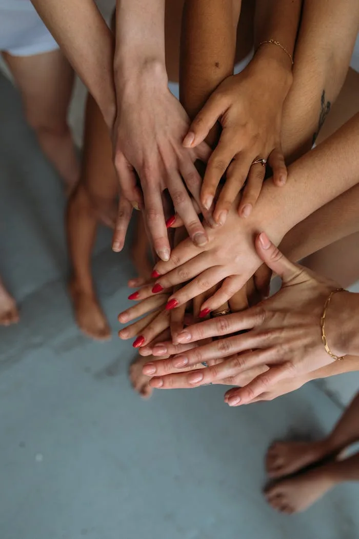 services-03 Close-up of diverse hands stacked together symbolizing unity and collaboration.