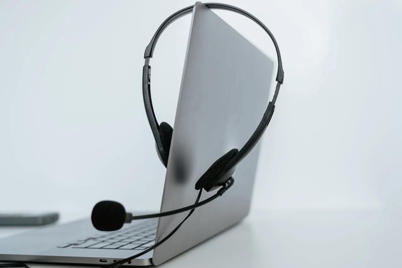 journey-01 Close-up of a laptop with a headset, symbolizing remote work or online communication.